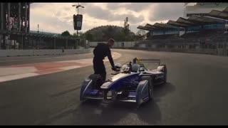 معلق زدن فوق العاده سریع یک بدلکار از روی ماشین فرمول E در حال حرکت